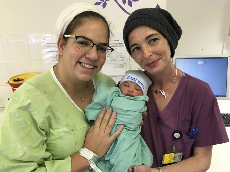 היולדת רבקה והמיילדת שרון עם הרך הנולד