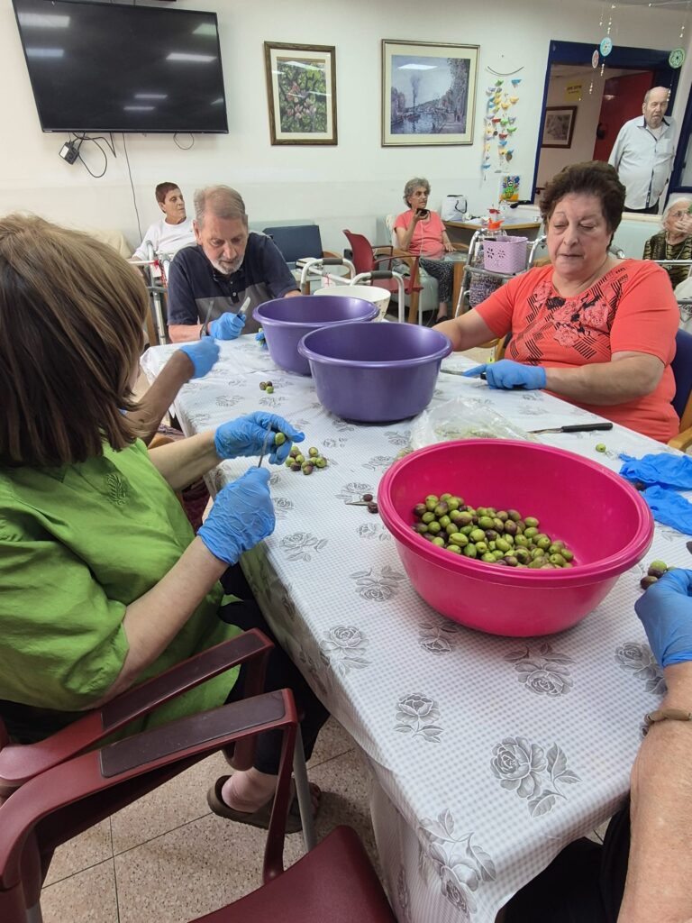 דיירי "עידן הזהב" בירושלים סביב שולחן עמוס זיתים, לימונים וצנצנות – מחייכים ומכבשים יחד את טעם הילדות