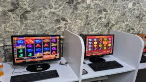 שוטרים בתוך מתחם חשוך בנהריה, מחשבים וכסף מזומן מונחים על שולחן - רגע הפשיטה כפי שצולם בדוברות המשטרה.