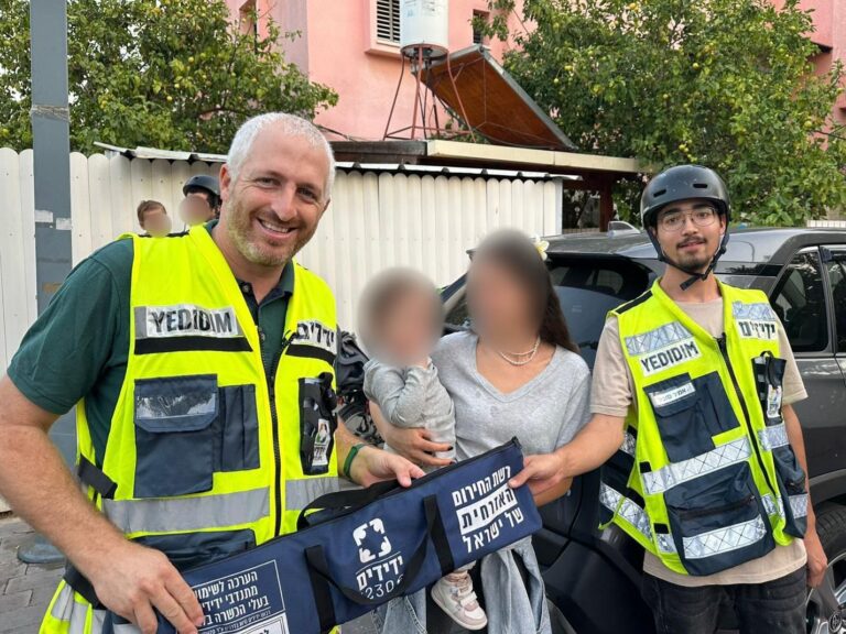 מתנדבי ידידים ליד רכב פתוח, פעוטה חוזרת לאמה, רגע של הקלה ונשימה