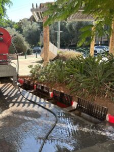 צוותי עיריית רחובות מנקים קולטני ניקוז ברחוב מרכזי בעיר, כחלק מההיערכות לחורף