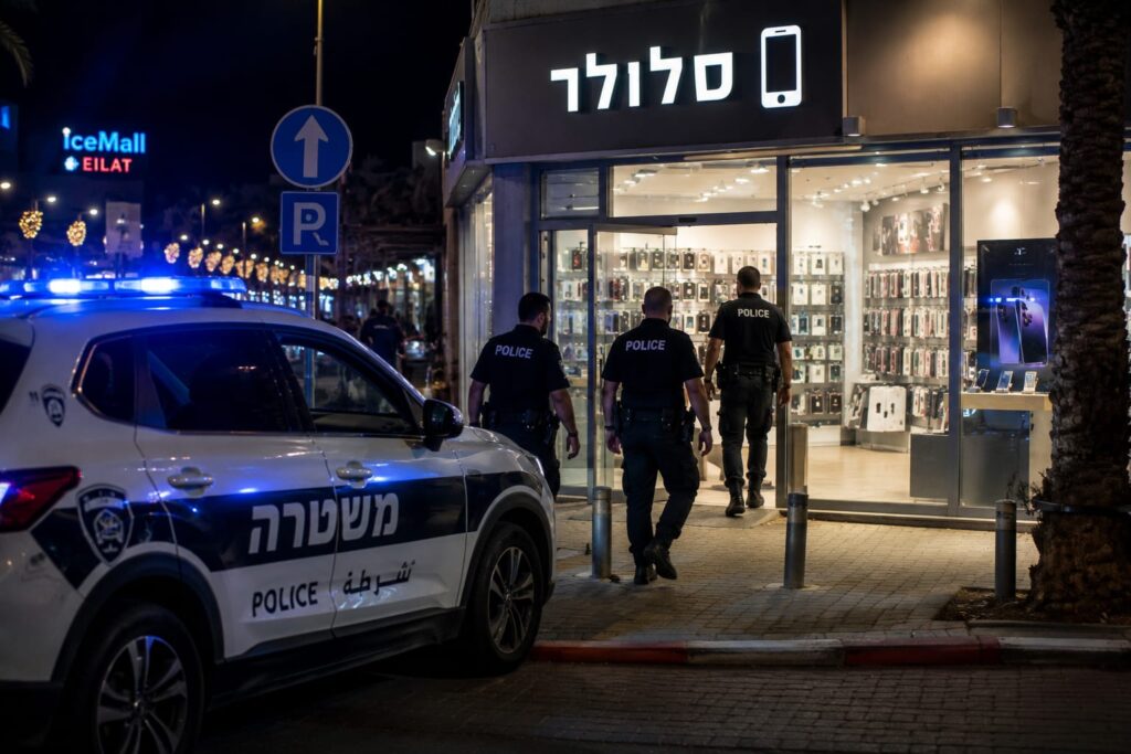 ניידות משטרה מחוץ לאזור מסחרי באילת לאחר שוד חנות סלולר. שלושה חשודים נעצרו זמן קצר לאחר האירוע