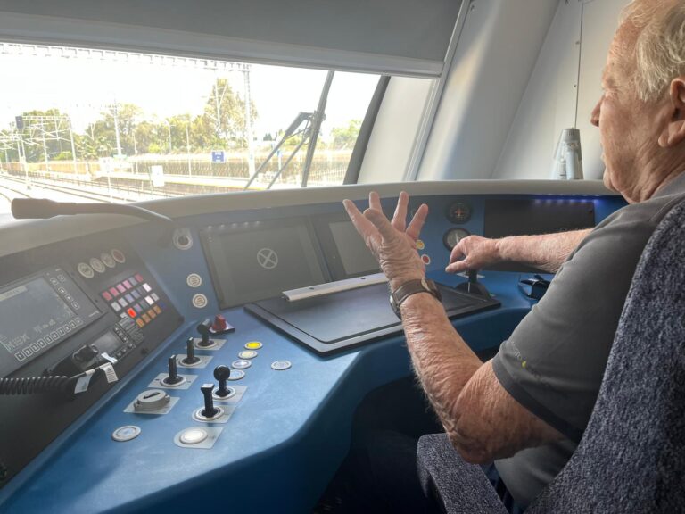 אריה עינב בן ה־80 מרעננה בתא הנהג של רכבת ישראל, לצד נהג הרכבת ולוחם המילואים אורן דה פז.