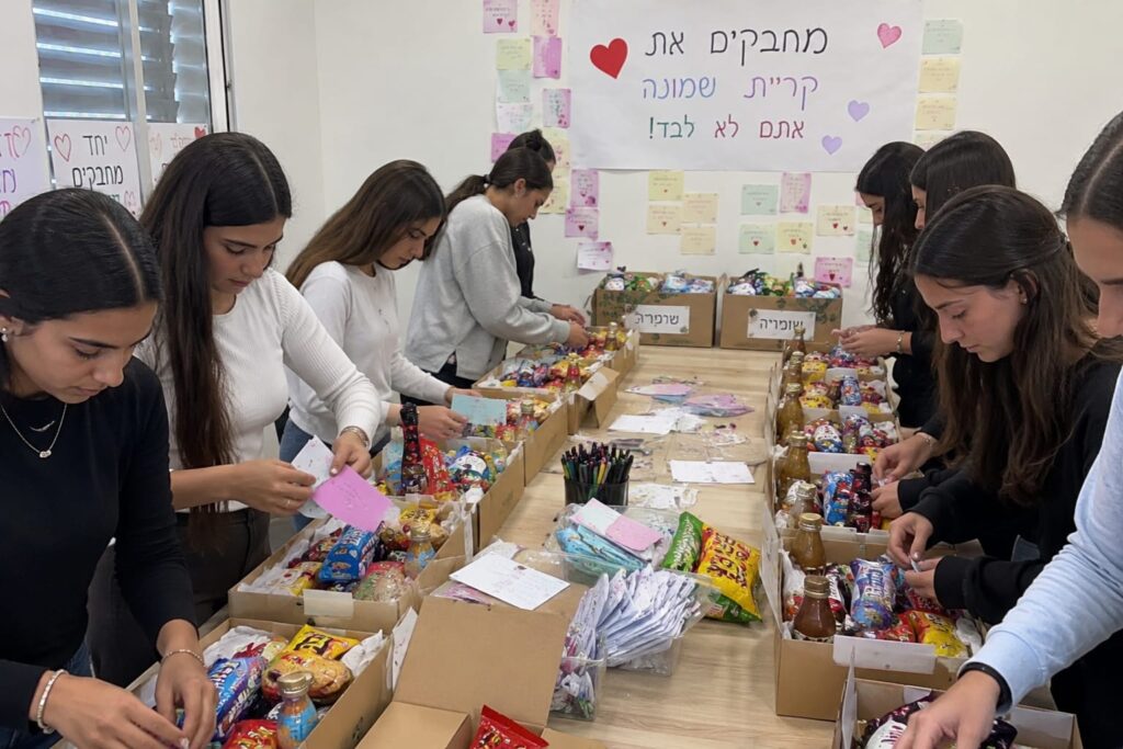 תלמידות מבית הספר בשומריה אורזות מארזי מתוקים שנשלחו לתלמידי קריית שמונה במסגרת יוזמה של חיבור וערבות הדדית בין הדרום לצפון