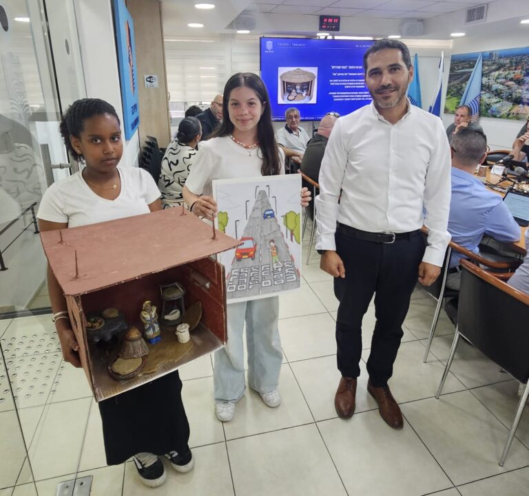 לפעמים גאווה עירונית מתחילה בשתי תלמידות צעירות שמזכירות לכולם שחינוך טוב לא מסתיים בכיתה - הוא מגיע גם לבמה של מועצת העיר.
