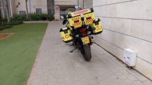 כונן חירום לצד אופנוע רפואי של מד"א מחוץ לבניין מגורים, במהלך תגובה לאירוע החייאה בנתיבות