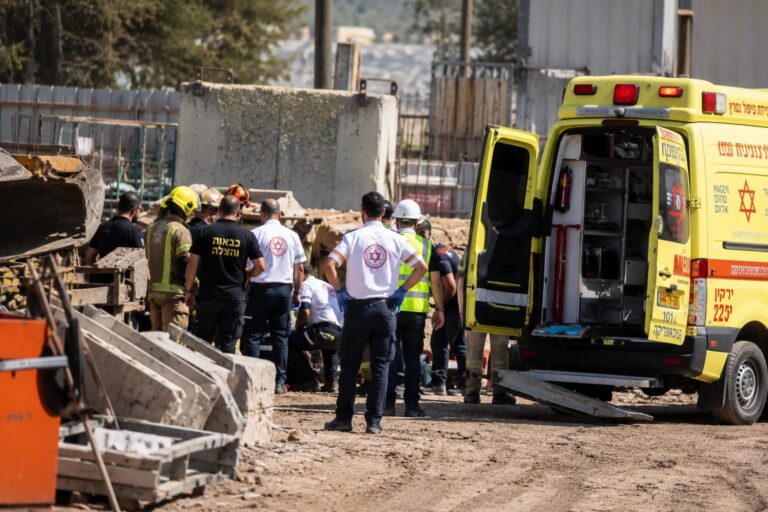 כוחות הצלה ורפואה פועלים באתר עבודה לאחר תאונת עבודה קשה, לצד אמבולנס וציוד חילוץ בזירה.