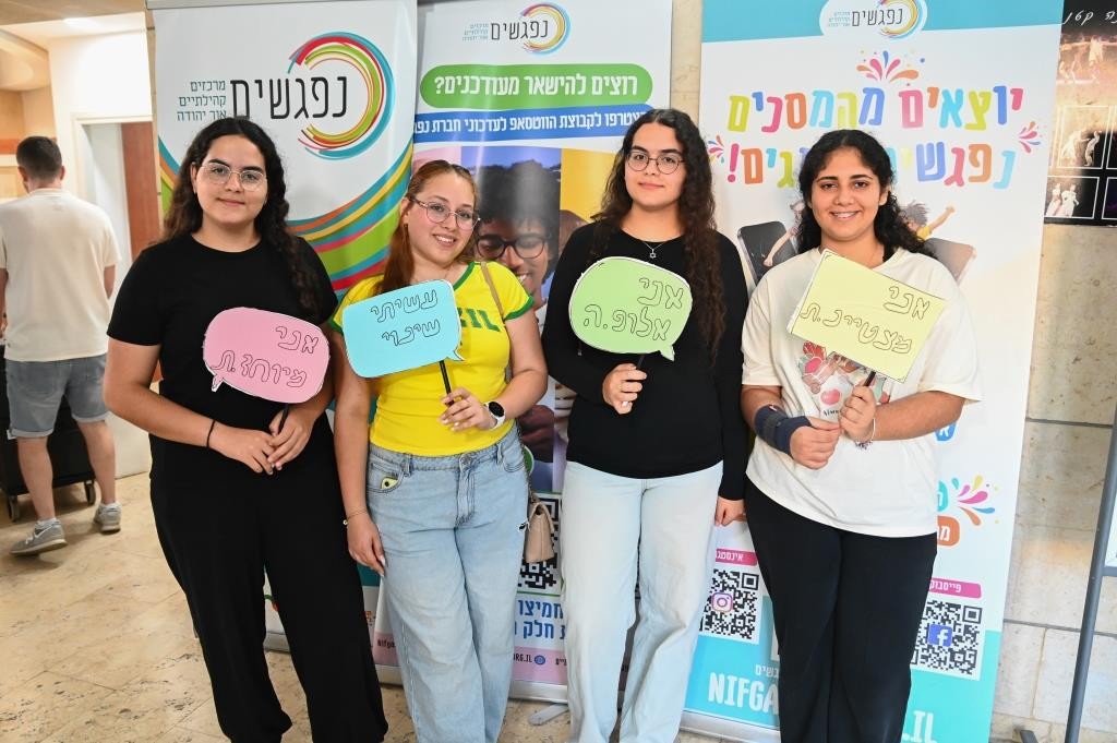 בני ובנות נוער עומדים על במה בטקס הוקרה עירוני באור יהודה, מחזיקים תעודות הוקרה לצד נציגי העירייה ובני משפחות בקהל