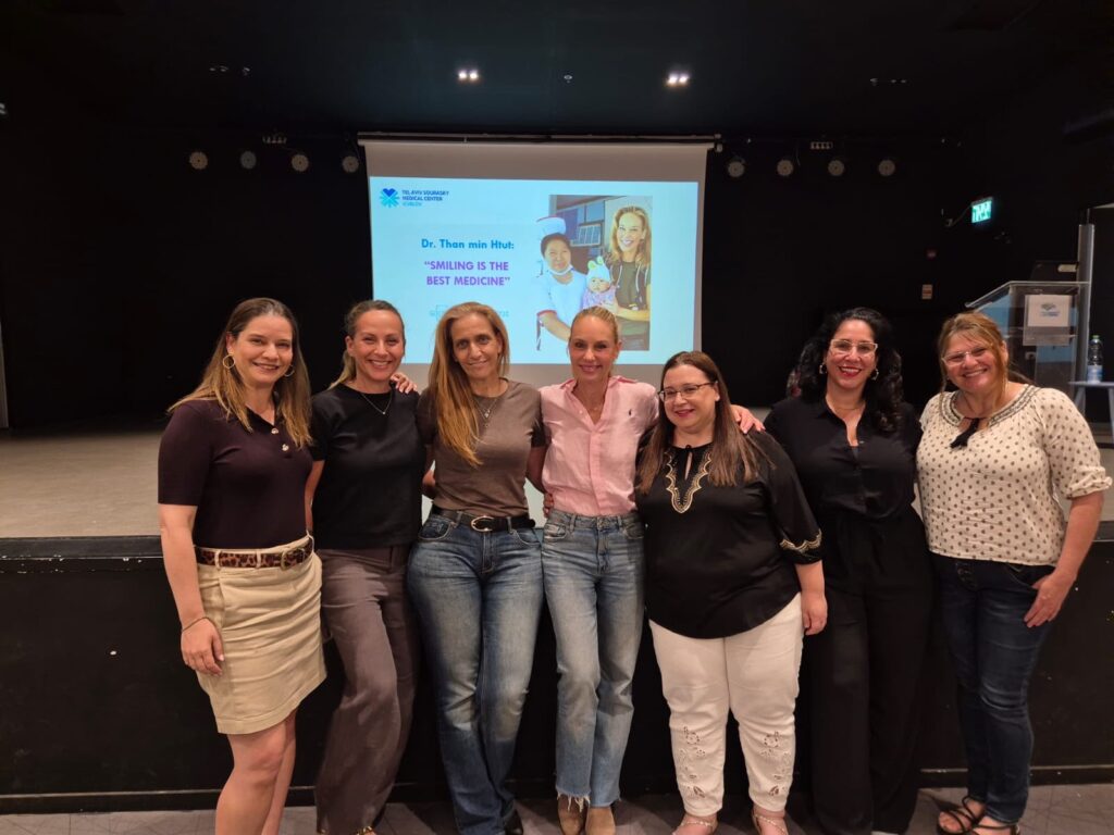 נשים משתתפות בהרצאה קהילתית בנושא בריאות האישה, יושבות באולם ומאזינות להרצאה מקצועית באווירה נעימה ומכבדת