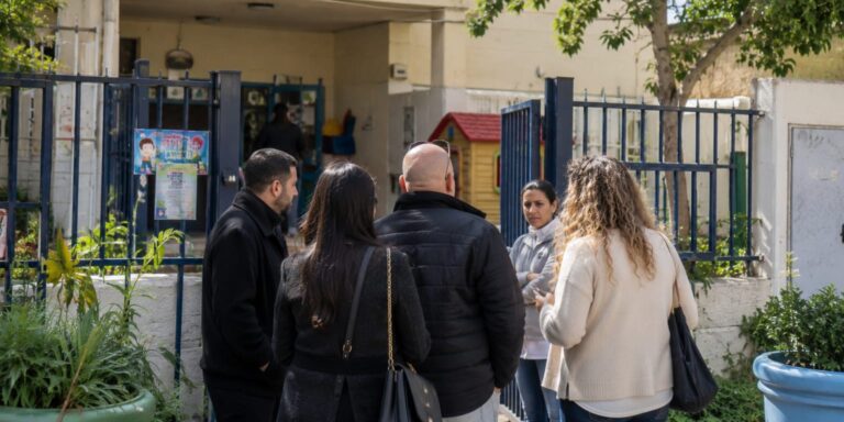 מוסד חינוכי בשכונה עירונית, לצד הורים ואנשי חינוך, כאשר גורמי העירייה מקיימים בדיקה ודיון מקצועי בעקבות אירוע חריג במסגרת החינוכית