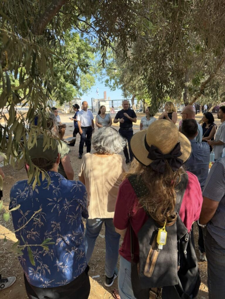 תושבים הולכים בשביל מוצל בפארק ההדרים ברחובות, בין עצים ומרחבים ירוקים, במסגרת פעילות עירונית המחברת בין טבע ובריאות