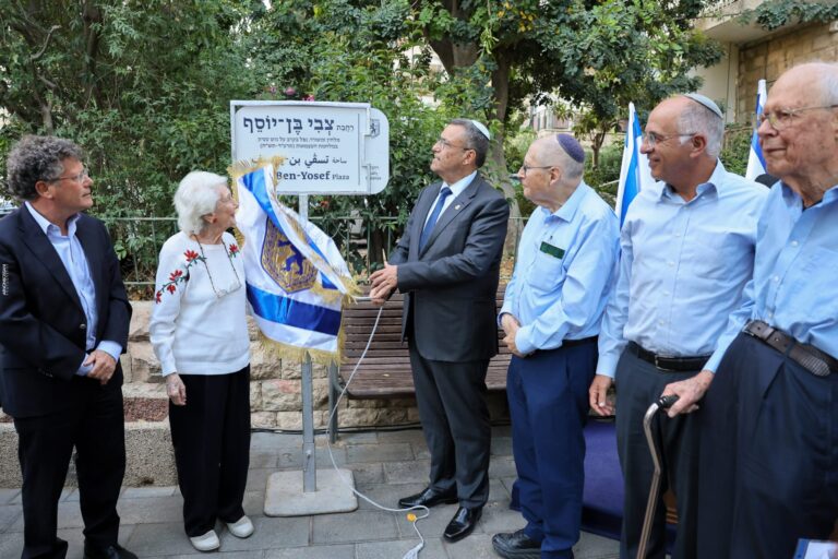 טקס חנוכת רחבה חדשה בשכונת רחביה בירושלים, עם שלט הנצחה, נציגי העירייה, מוקירי זכרו ותושבים, באווירה מכובדת של זיכרון, תרבות והיסטוריה עברית