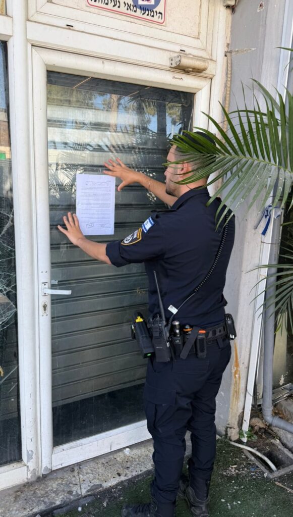 משטרה מחוץ לבית עסק בשעות הלילה, לצד שלט פאב סגור ואזור בילוי ריק, באווירה המדגישה אכיפה נגד מכירת אלכוהול לקטינים