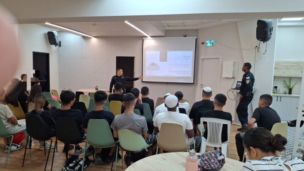 שוטר מרצה בפני תלמידי תיכון בכיתה בקריית מלאכי, כאשר התלמידים מקשיבים להרצאה בנושא אחריות אישית, חוק הנוער והשלכות של מעורבות בפלילים בגיל צעיר