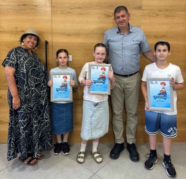 שלושה ילדים מגבעת שמואל קוראים ספרים בספרייה העירונית במסגרת שבוע הספר.