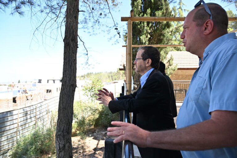 נשיא המדינה יצחק הרצוג נוטע עץ במשואות יצחק הישנה בגוש עציון, לצד ותיקי ההתיישבות ותושבי האזור, על רקע נופי ההרים והגבעות שבהם צפוי לקום היישוב החדש "משואות הר"