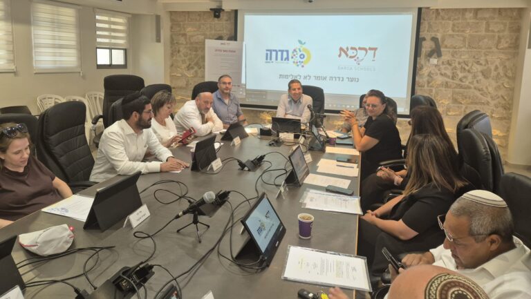 ישיבת מליאת מועצת גדרה בהשתתפות בכירי משרד הפנים, על רקע הצגת נתונים כלכליים וגרפים המסמלים מעבר מגירעון לעודף תקציבי