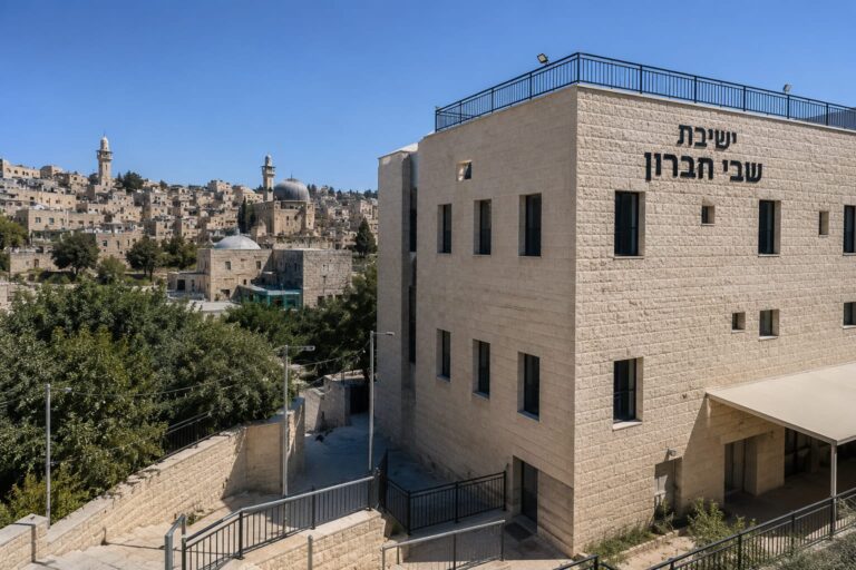 מבנה ישיבת שבי חברון באזור בית רומנו בחברון, לצד נוף עירוני של העיר העתיקה ומבני אבן אופייניים, על רקע דיוני התכנון והבנייה החדשים בעיר