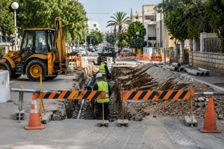 עבודות תשתית ברחוב עירוני לצד שילוט המכוון נהגים להסדרי תנועה זמניים