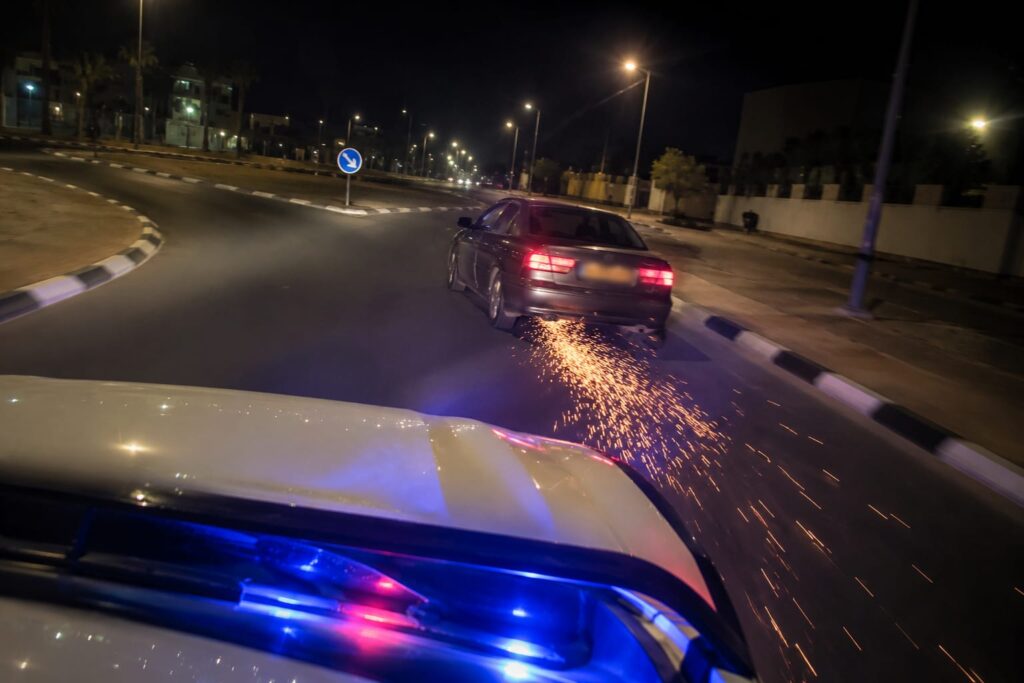 ניידת משטרה נוסעת בעקבות רכב בכביש עירוני במהלך פעילות אכיפה נגד עבירות תנועה מסכנות חיים