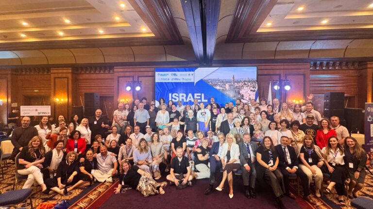 נציגות מחלקת הקליטה של קריית גת משוחחות עם משתתפים ביריד עלייה באלמטי ומציגות מידע על החיים בעיר