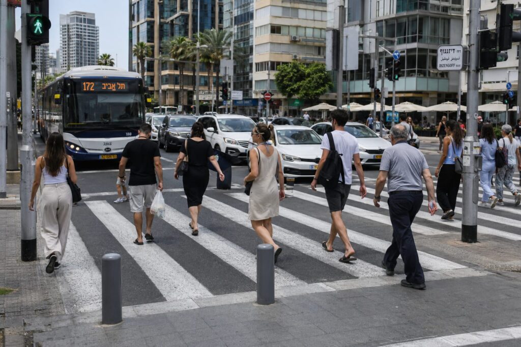 הולכי רגל חוצים מעבר חציה במרכז העיר בשעות העומס
