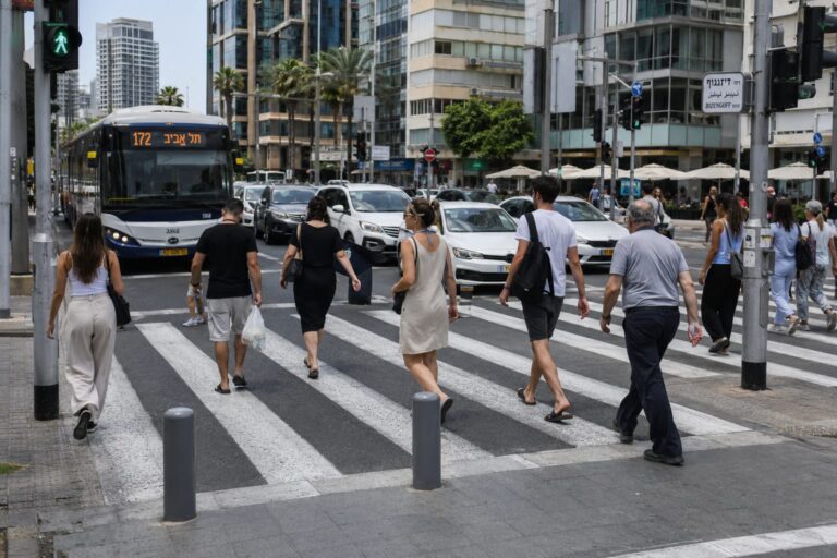 הולכי רגל חוצים מעבר חציה במרכז העיר בשעות העומס