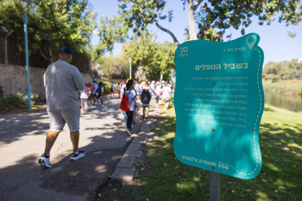 משתתפים צועדים לאורך "שביל המעשים הטובים" בפארק לכיש במהלך אירוע החנוכה באשדוד