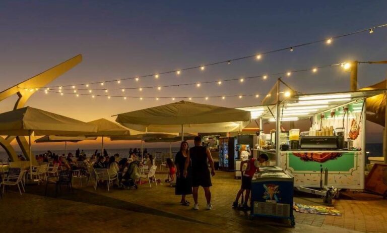 תאורת גרילנדות חדשה במתחם הפודטראקים לאורך טיילת רפאל איתן באשקלון בשעות הערב.