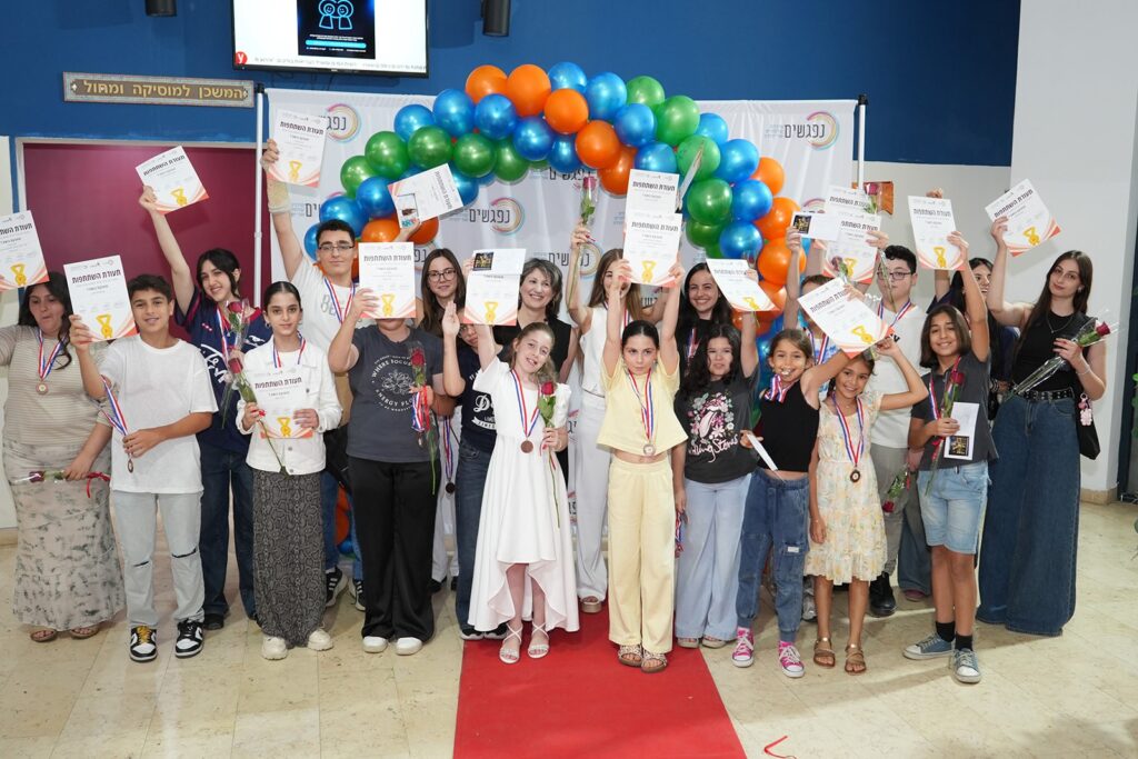 צילום כל משתתפי התחרות על הבמה בביצוע המשותף ל“לו יהי”, לצד תזמורת כלי הנשיפה והזוכים עם המדליות