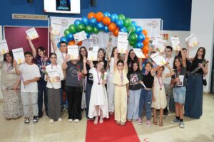 צילום כל משתתפי התחרות על הבמה בביצוע המשותף ל“לו יהי”, לצד תזמורת כלי הנשיפה והזוכים עם המדליות