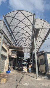 התקנת לוחות הקירוי מעל דוכני שוק רמלה בזמן שהמסחר ממשיך לפעול