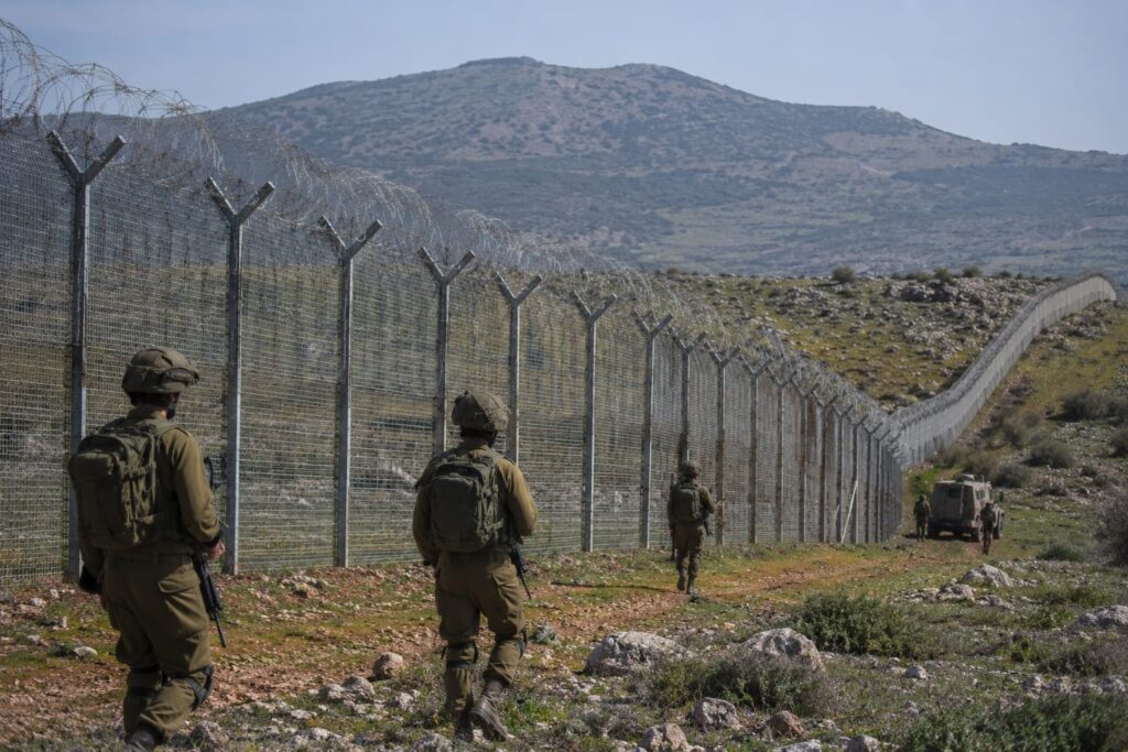 גדר הגבול באזור מג'דל שמס או דרום רמת הגולן, עם כוחות צה"ל מסיירים במרחב