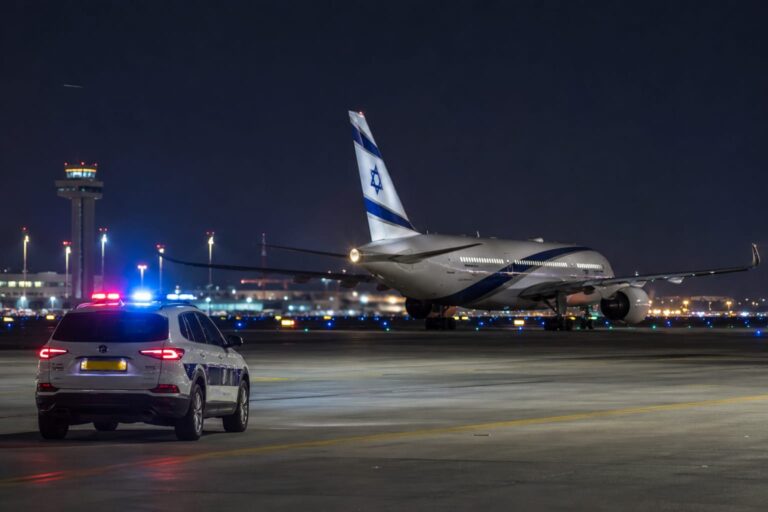 אילוסטרציה של מטוס נוסעים על מסלול ההמראה בנתב"ג ולצדו ניידת משטרה