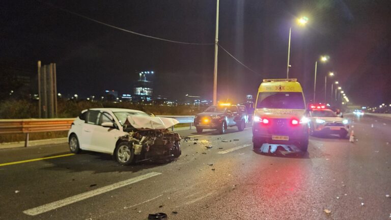 זירת תאונת דרכים לילית בכביש מהיר עם ניידות מד"א ומשטרה, אורות חירום וכלי רכב פגועים מטושטשים