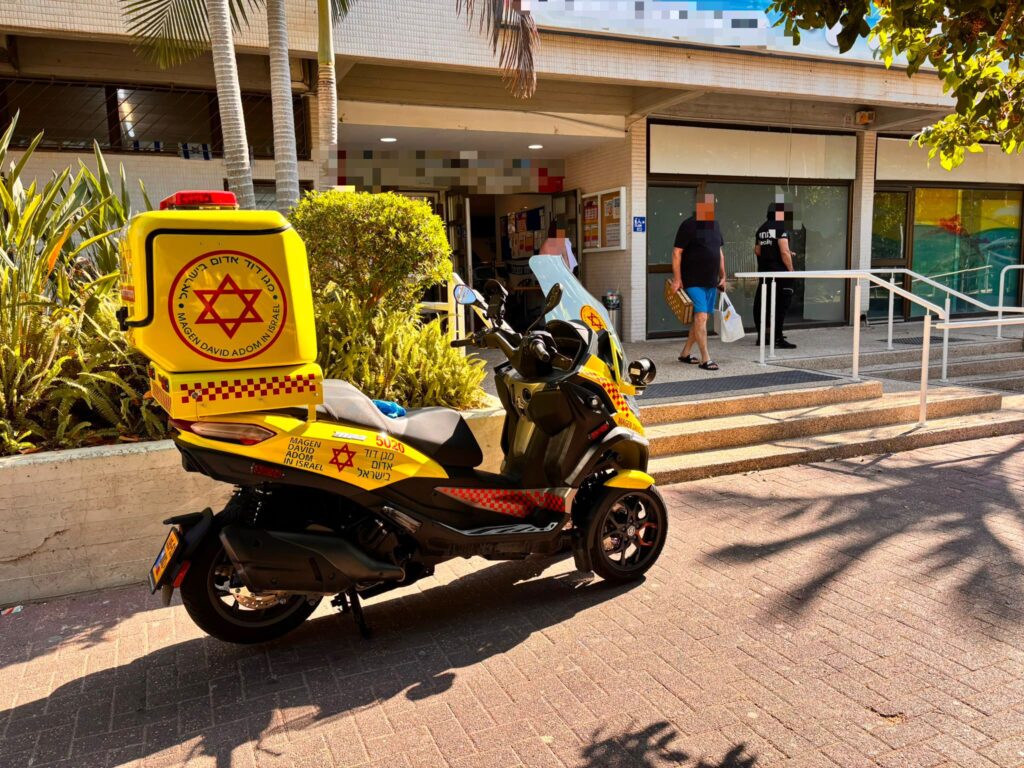 כוחות מד"א מעניקים טיפול רפואי סמוך לבריכה הציבורית בחולון לאחר חילוץ ילד מהמים.