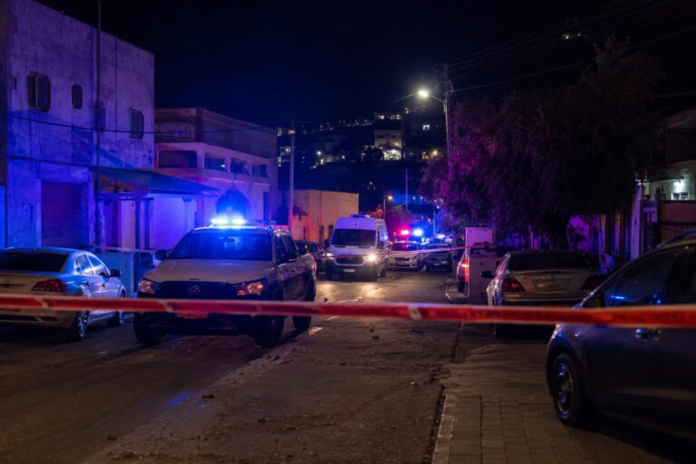 ניידות משטרה וכוחות ביטחון ברחוב מגורים בערערה בנגב בשעות הלילה, עם סרטי סימון משטרתיים ואורות מהבהבים