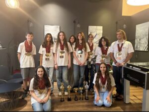 תלמידי נבחרת הדיבייט מרחובות מחזיקים מדליות וגביעים באולם התחרות בפראג