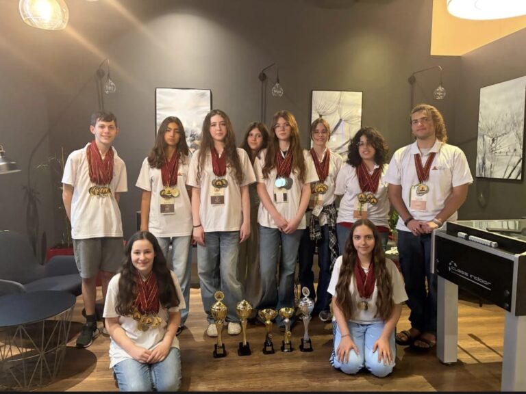 תלמידי נבחרת הדיבייט מרחובות מחזיקים מדליות וגביעים באולם התחרות בפראג