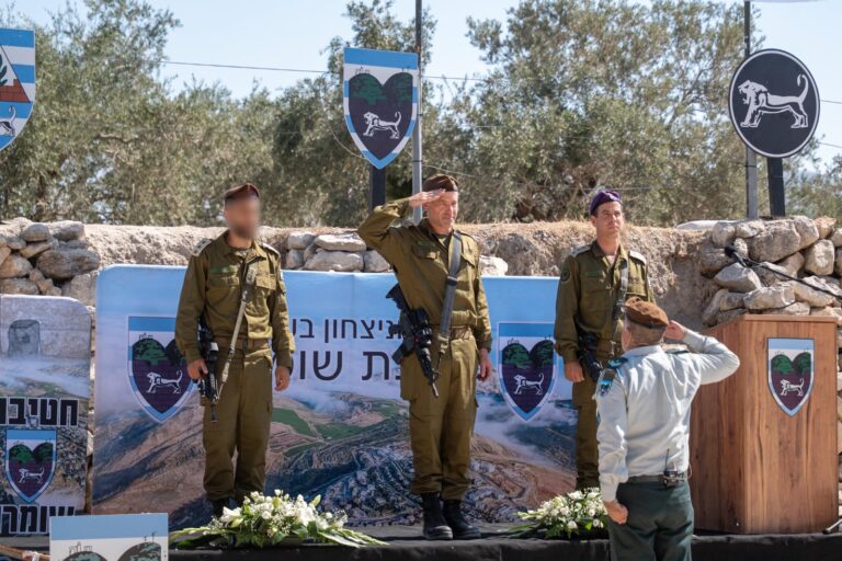 טקס חילופי מפקדי חטיבת שומרון, עם שני הקצינים לוחצים ידיים לצד דגלי ישראל וצה"ל, בנוכחות מפקדים ולוחמים