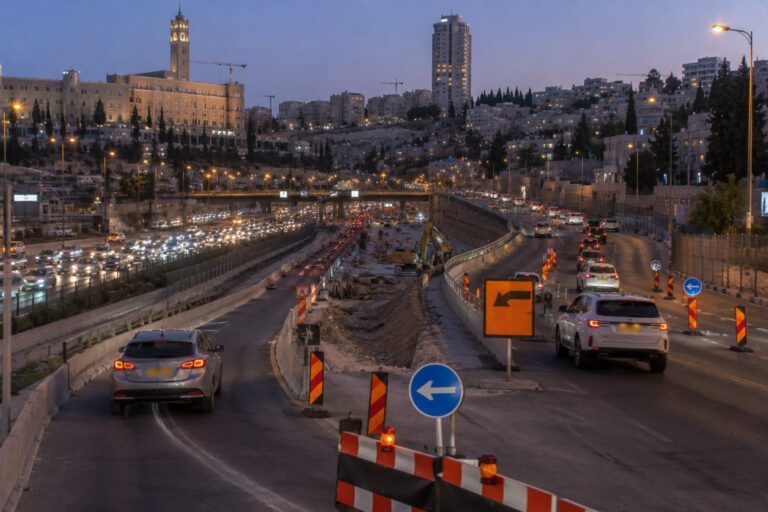 כביש בגין בירושלים בשעות הערב, עם מחסומי תנועה, עבודות תשתית וכלי רכב המופנים לדרכים חלופיות
