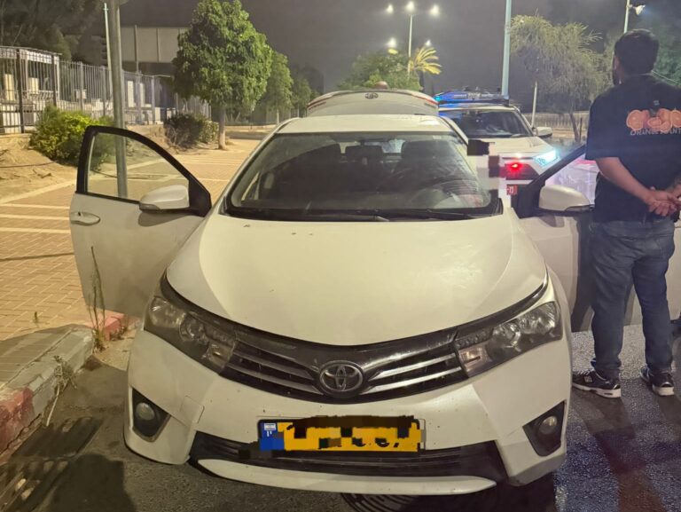 ניידת משטרה עוצרת רכב ברחוב עירוני בבאר שבע במהלך פעילות אכיפה